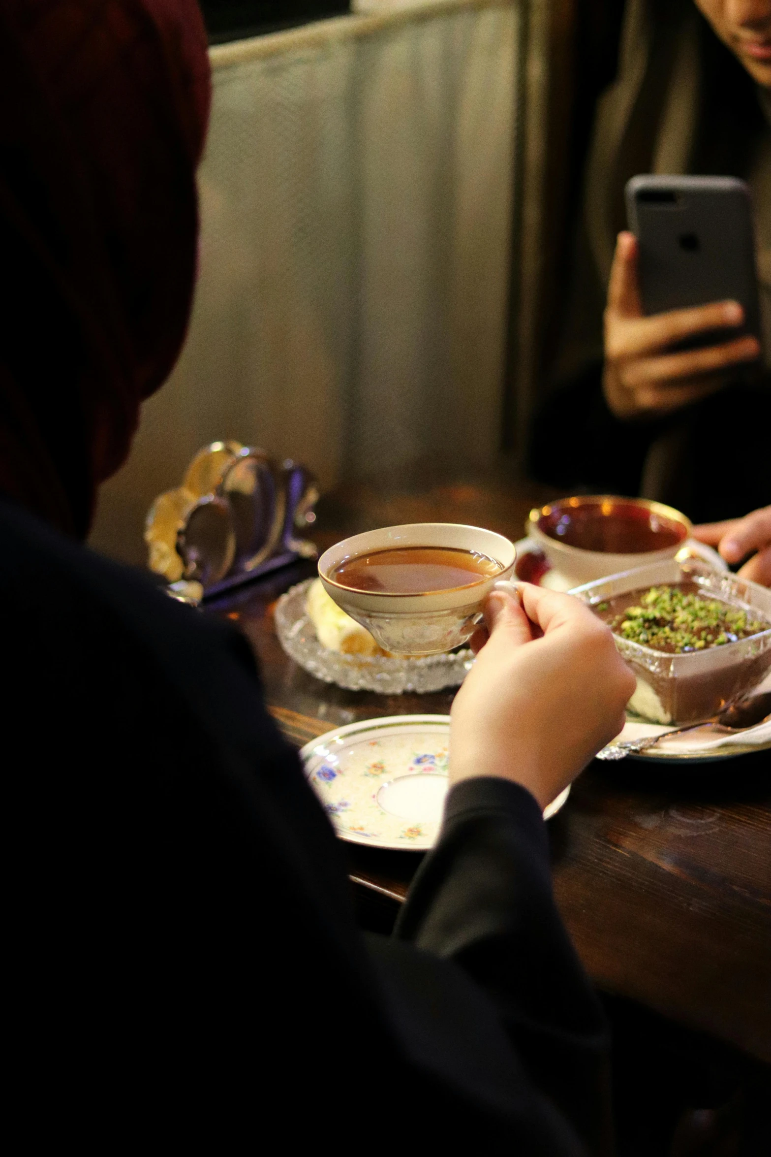 a man sitting at a table holding a cellphone