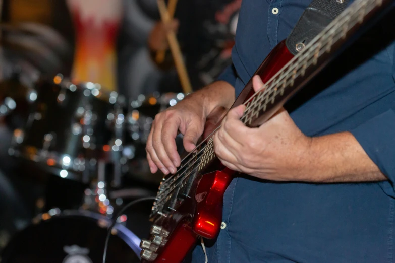 a man playing the guitar and wearing a blue shirt