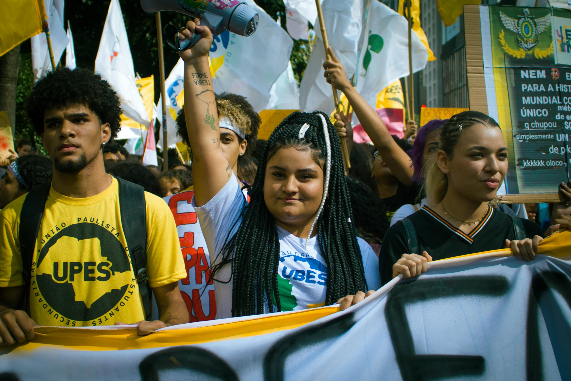 people holding up signs and banners while others protest