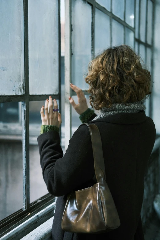a woman pointing at her hand out the window
