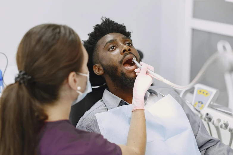 a dentist is adjusting a womans teeth