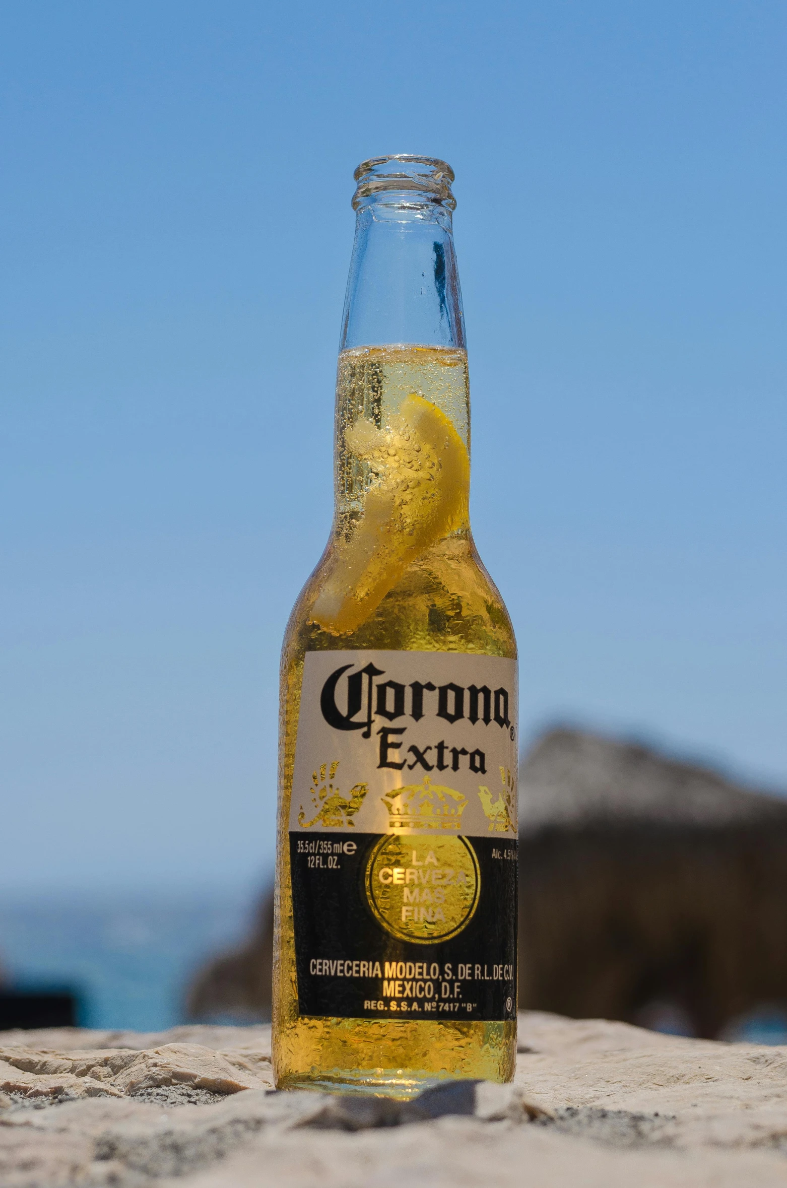 a bottle of corona beer sits on the beach