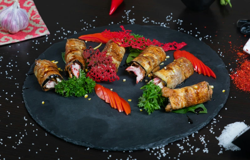 small group of different foods are arranged on a circular black platter