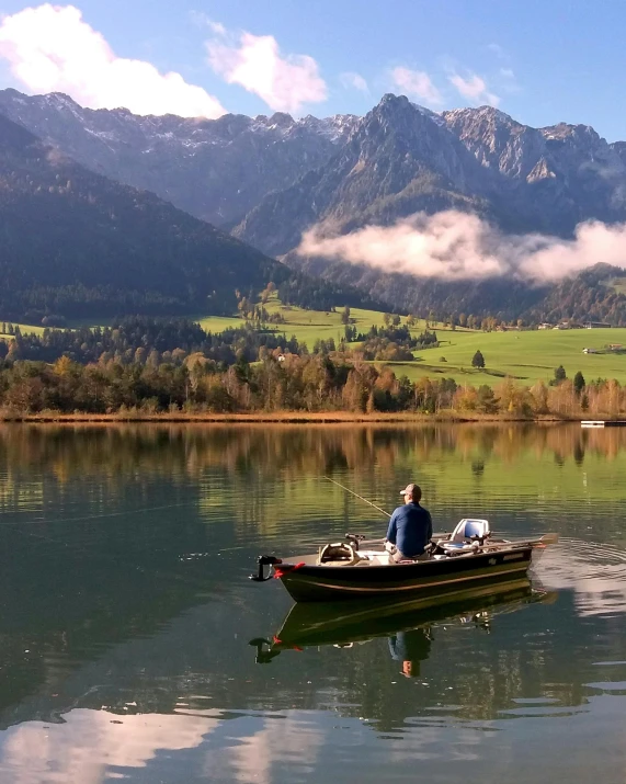 a man is rowing a small boat on the lake