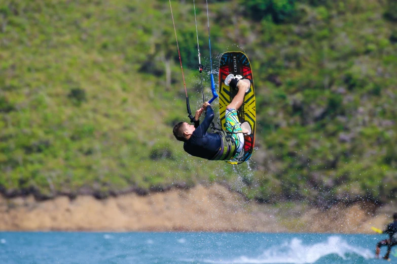 a man is doing tricks with his kiteboard in the air