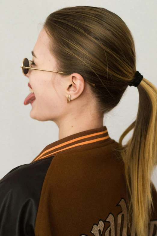 a woman with a ponytail is wearing a baseball jersey