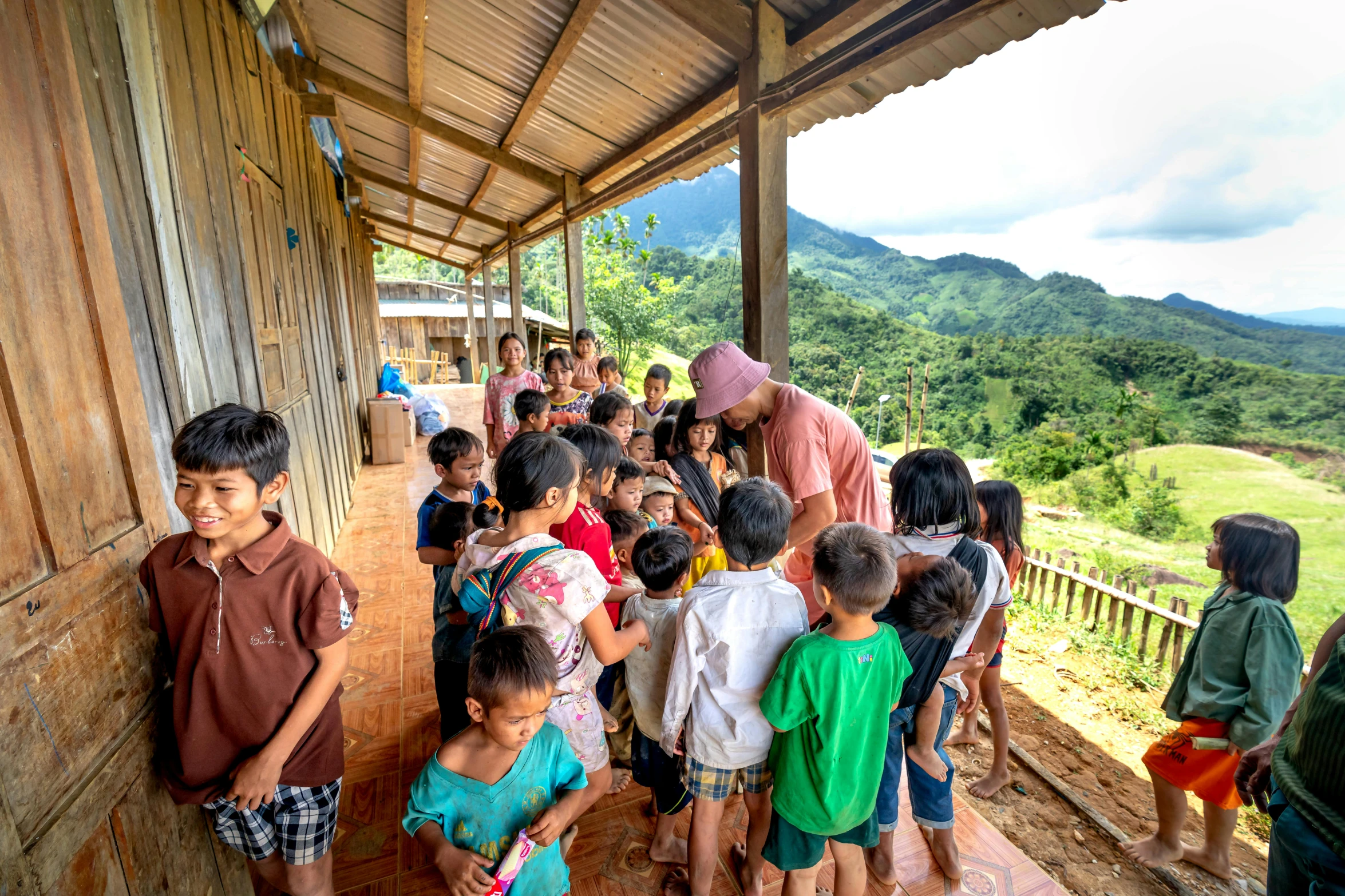 children and adults stand together at a shelter