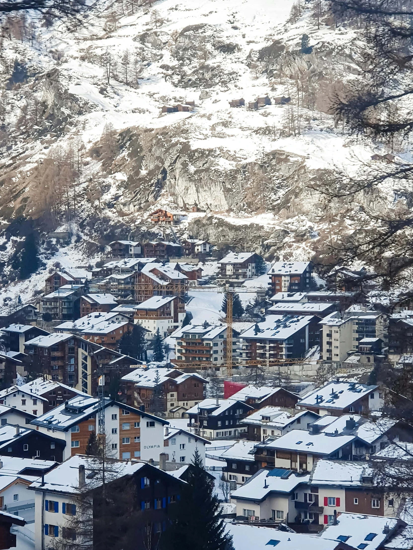 view of mountains, houses and snow covered hillside