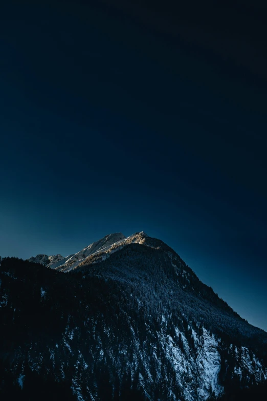 a lone mountain peak with a snow - capped top