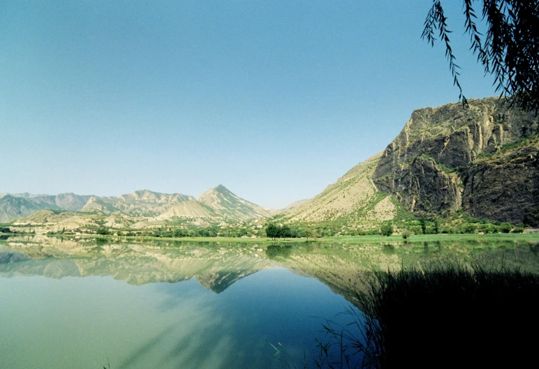 some water mountains and trees and a blue sky