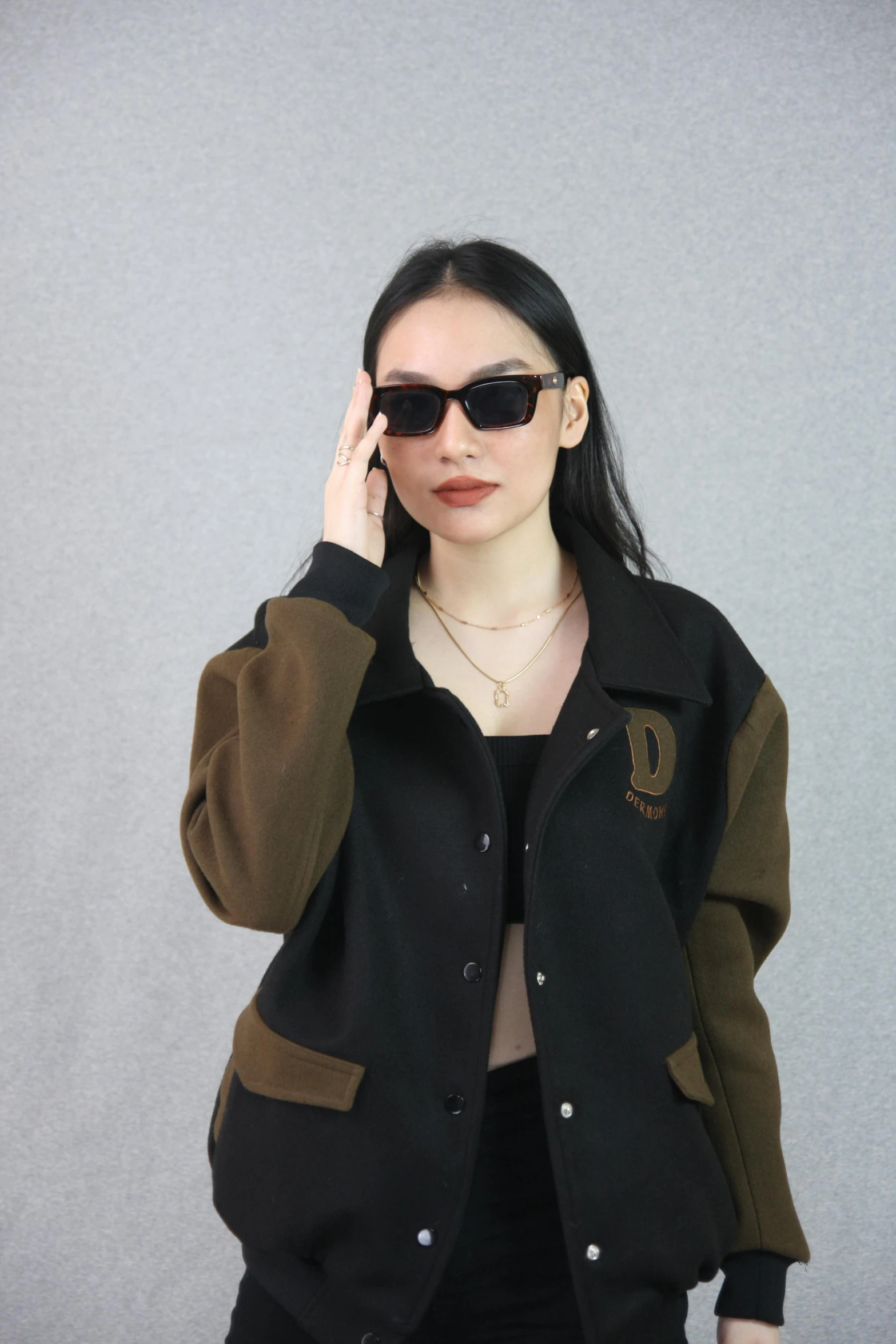 the woman with her hand on her ear wearing sunglasses