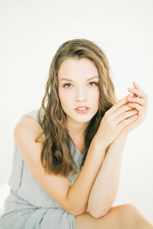 a woman is sitting on the floor looking into the camera