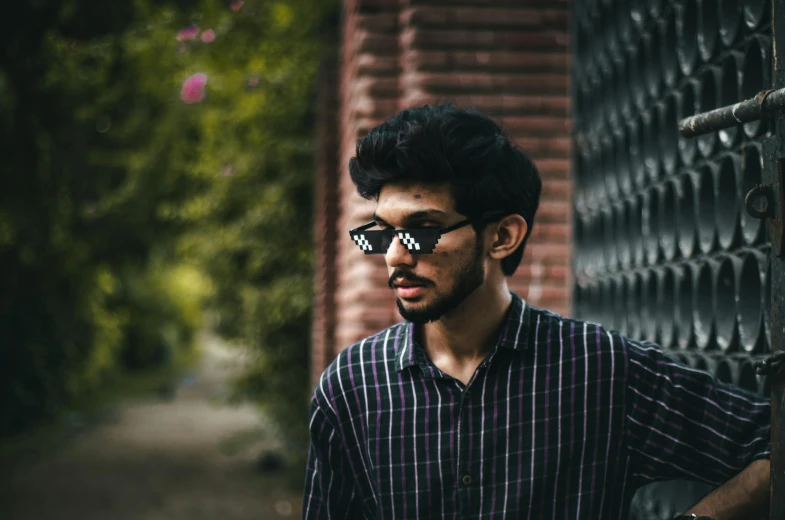 a young man wearing glasses and looking to the side