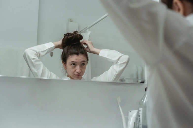 woman looking at herself in the mirror brushing her hair