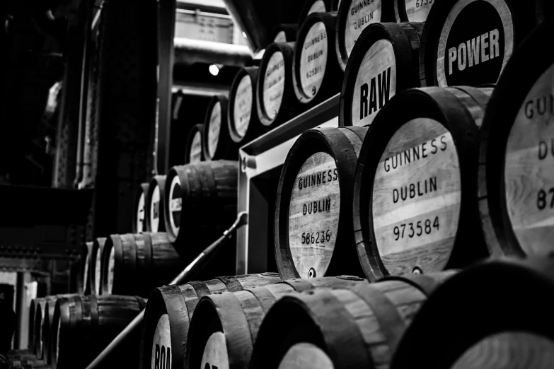 many wooden barrels are stacked on top of each other