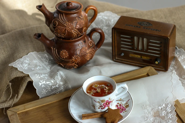 a cup of tea on a saucer with a small wooden device