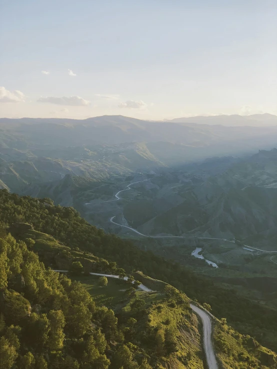 a beautiful landscape with green trees and the road