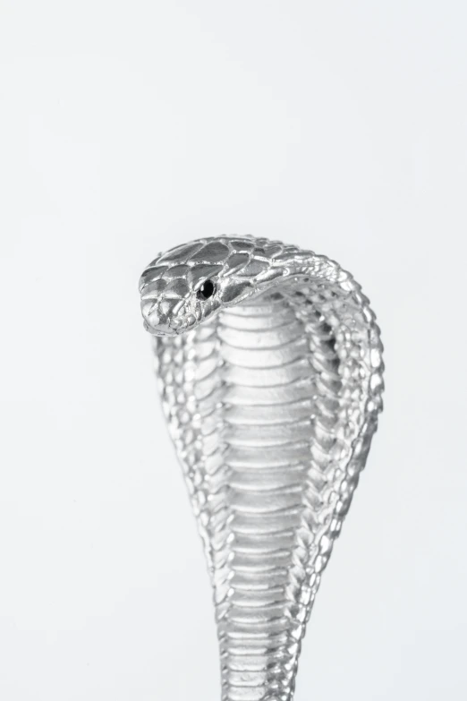 a small snake shaped vase sitting next to a white wall