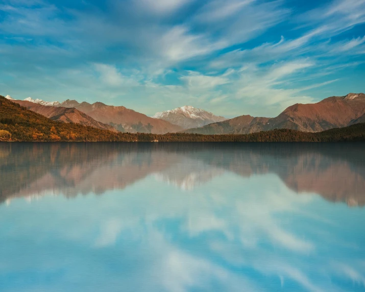 the water is blue and clear with mountains in the background