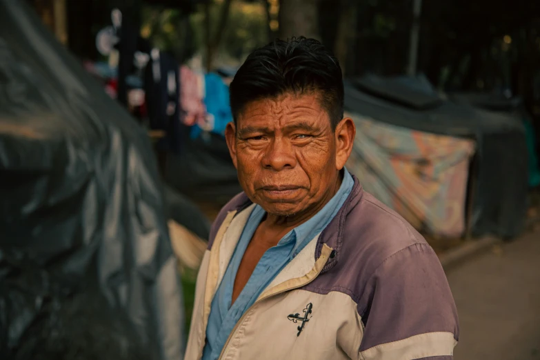 a man is standing outdoors looking at the camera