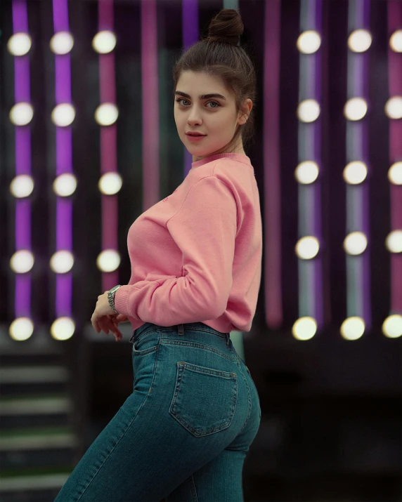 a girl posing on a stage in blue jeans