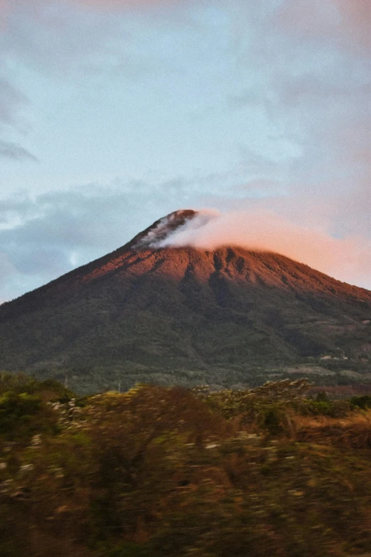 the mountain is covered in a cloud by low trees