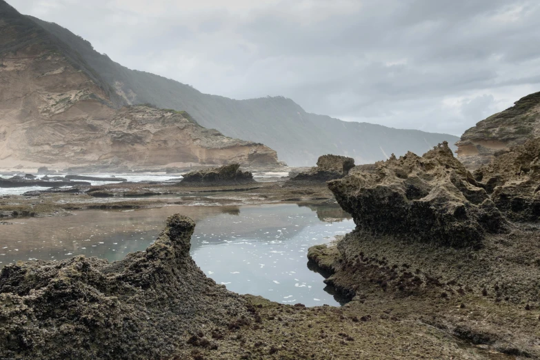 a lake and rocky shoreline in the middle of a mountain