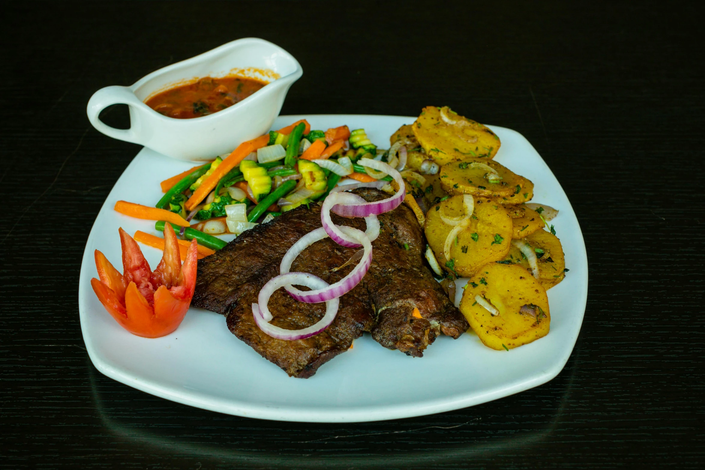 a white plate topped with steak, veggies and sauce