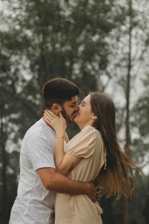 couple sharing a moment together in an open field by some trees