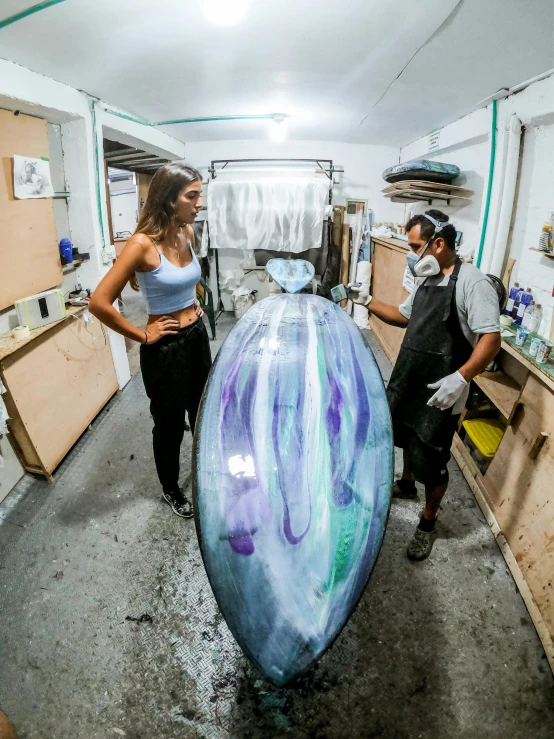 two people standing inside of a painting studio