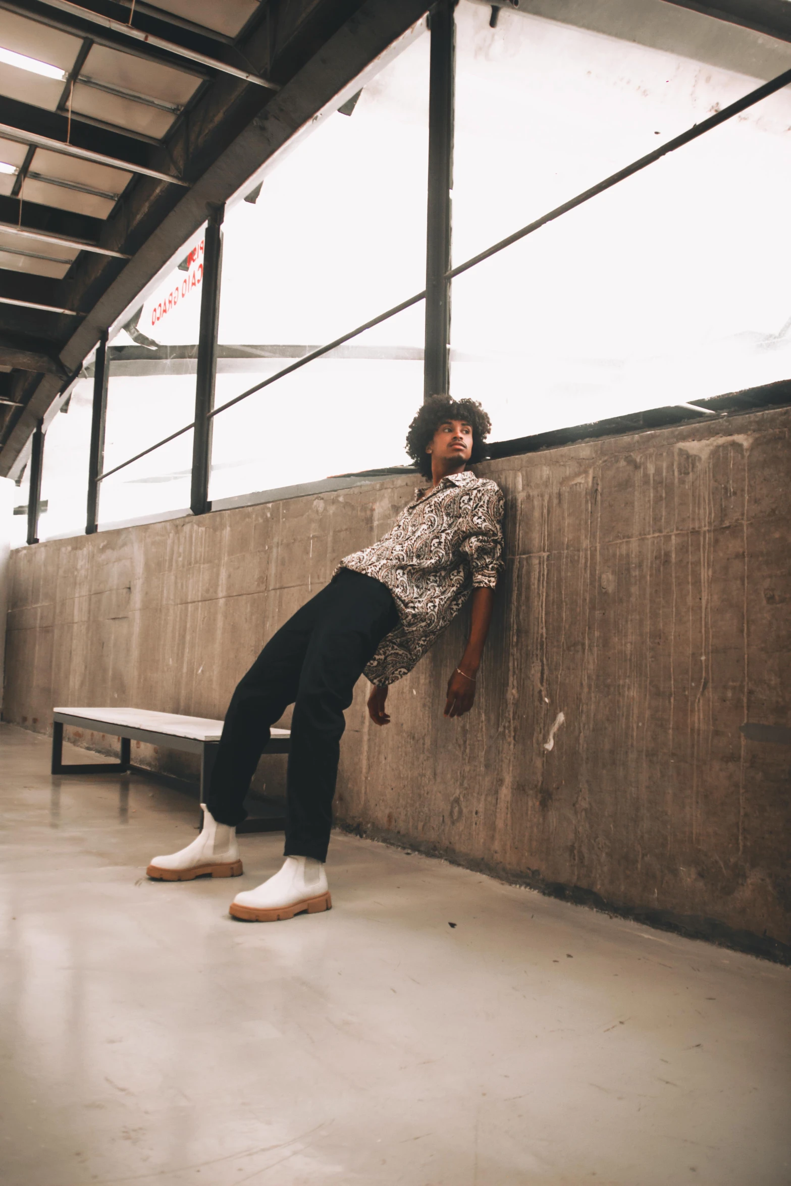 a man sitting on top of a stone wall