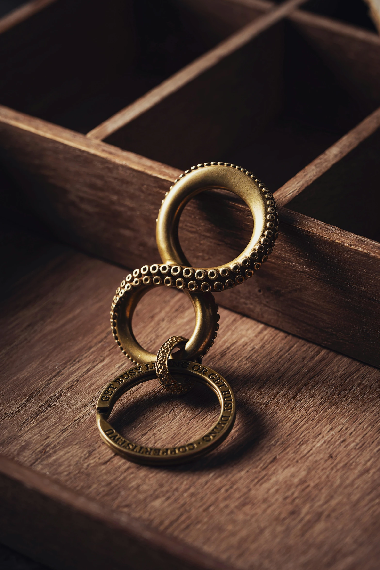 two gold rings are laying on a brown table