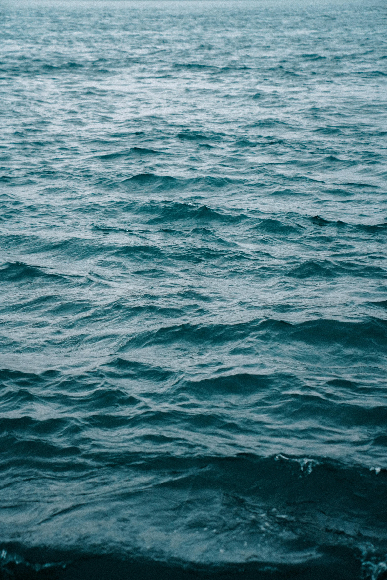 an ocean with large blue waves crashing in to shore