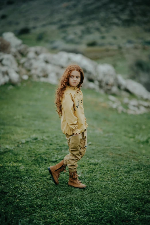 a little girl standing in the grass with long hair