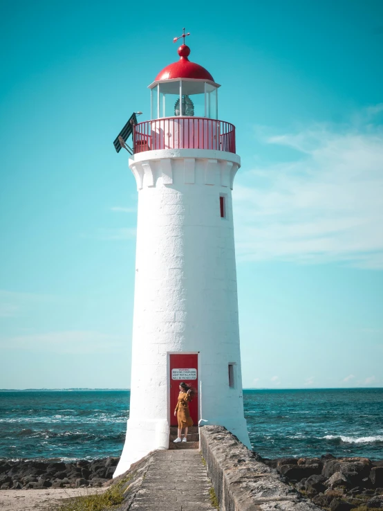 a lighthouse on the shore with its door open