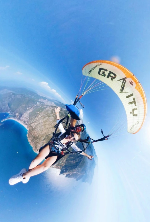 person para sailing over the blue ocean while holding on to a parachute