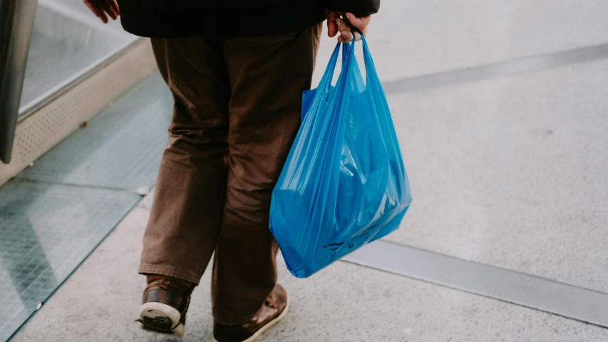 a person with two bags walking on an escalator