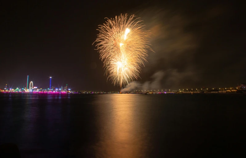 an fireworks display above the water and a city at night