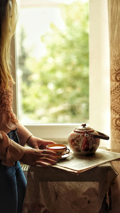 a woman sitting in front of a window with an empty bowl on the table