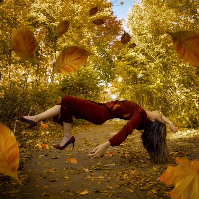 a woman is in the middle of the leaves of a path