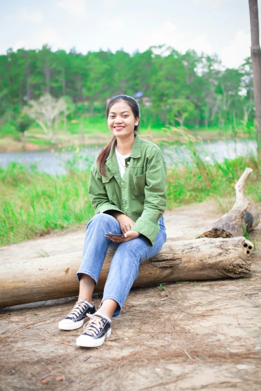 a girl sitting on a log in a park