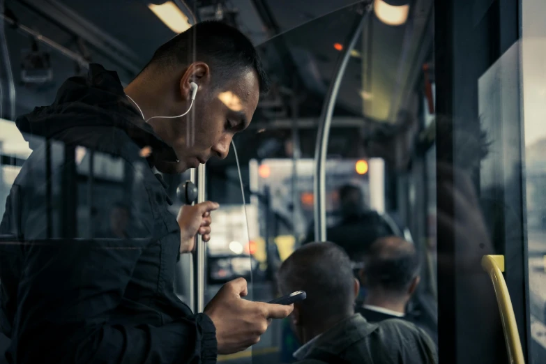 a man is on a bus using his cell phone