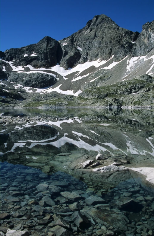 the view from above a mountain looking down on rocks and water