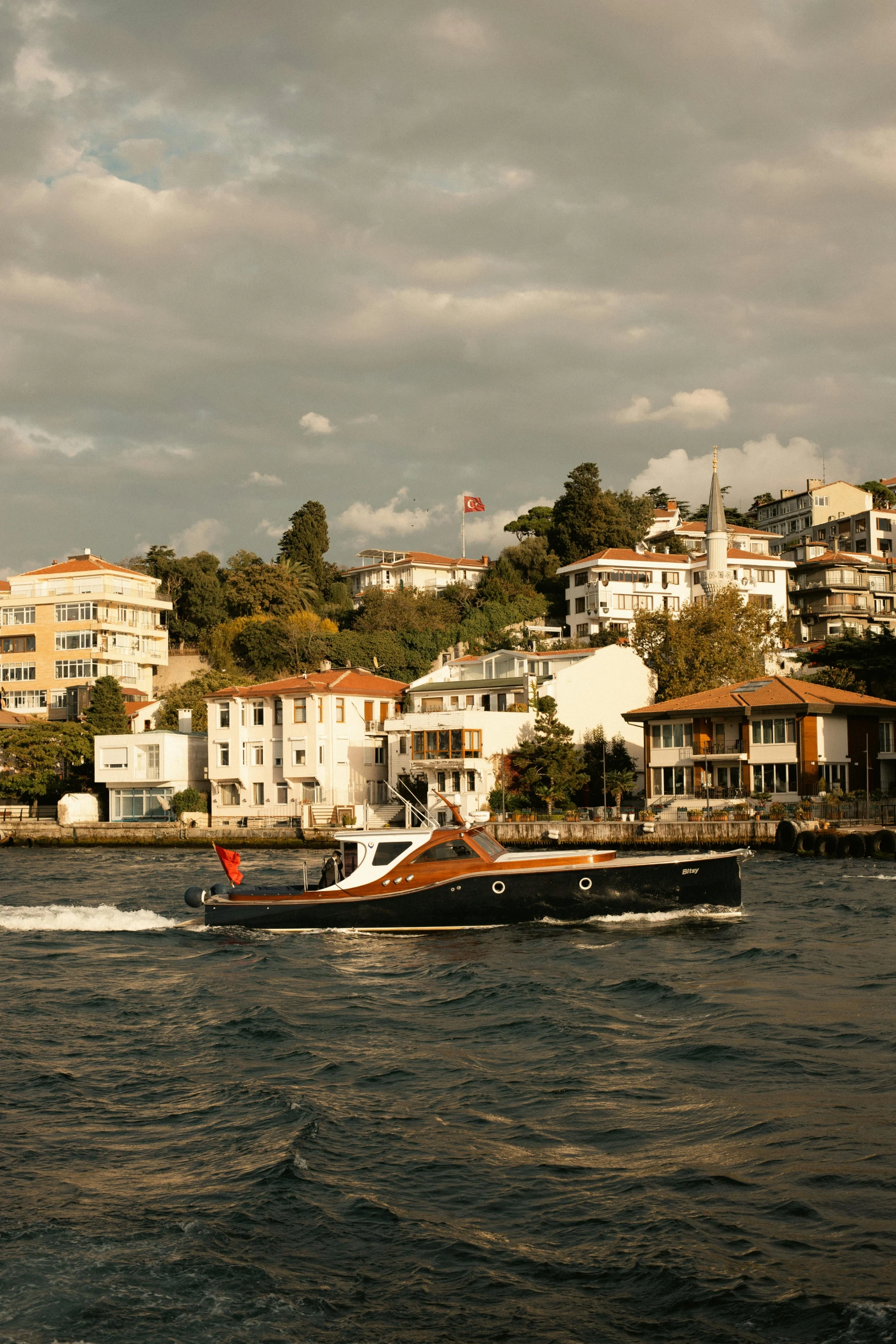 a boat sailing in the water near some houses