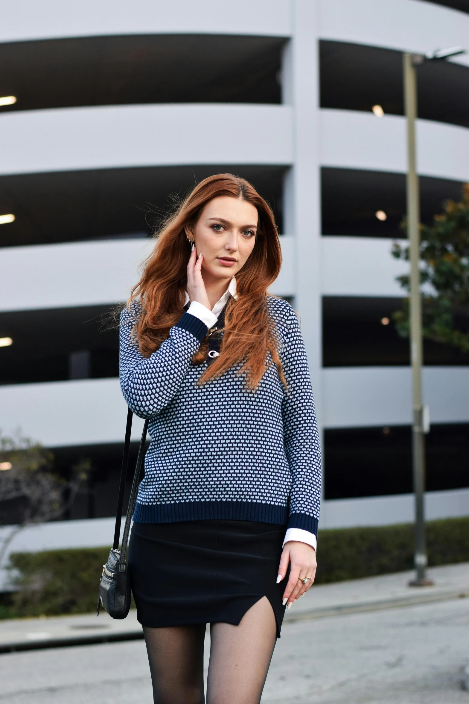 a woman standing on the side walk talking on her phone