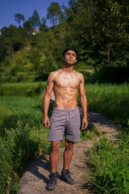 a young man walking in front of trees