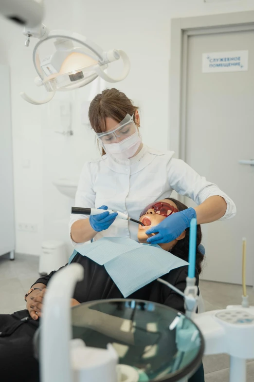 a woman in white coat getting hair cut