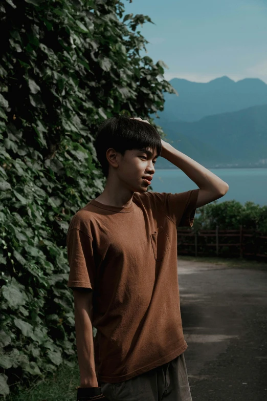 a young man holding his hat is standing on the path