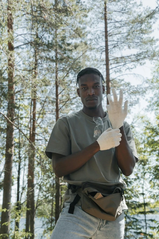 a man standing in the forest holding his hands in the air