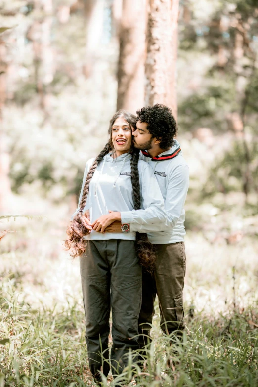 two people that are hugging each other in the woods